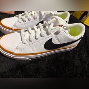 Nike White Low-Top Sneakers with Black Swoosh and Gold Accent